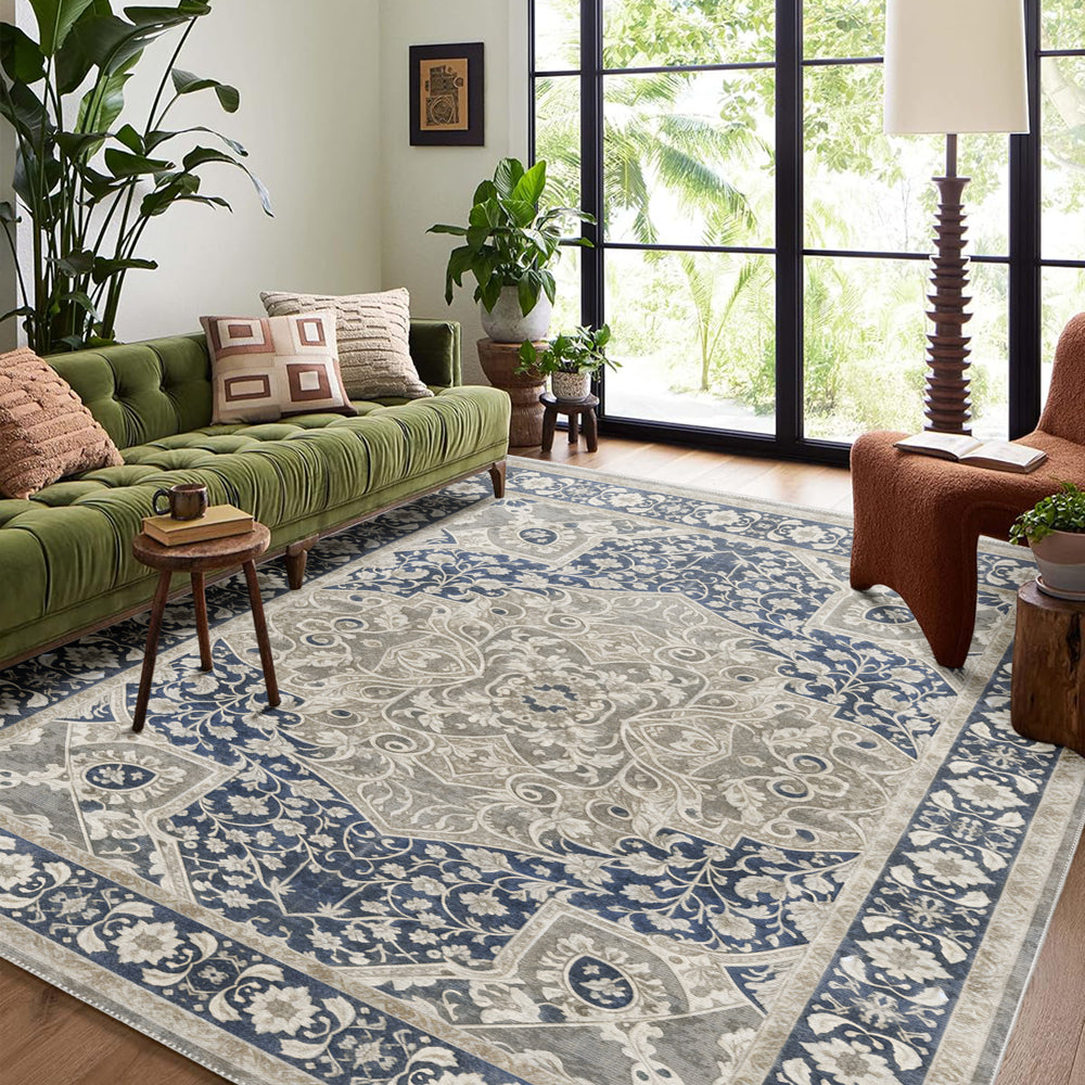 Living room with a green sofa, patterned rug, and large windows.