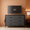 Gray dresser with a television displaying '32”' in a room with a lamp and wooden sideboard.